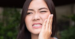 Woman in pain holding her cheek