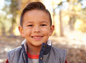 little kid standing outdoors smiling