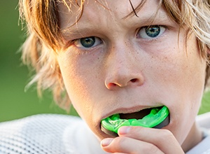 kid putting athletic mouth guard on
